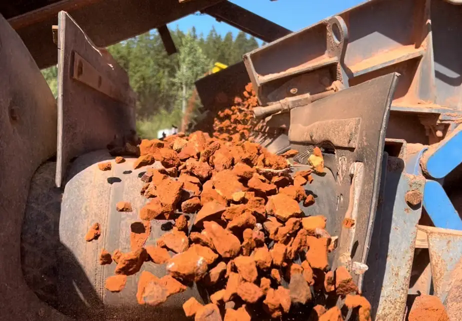 Knust teglstein på transportbånd under sortering i knuseanlegg.